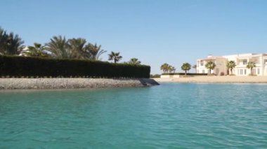 El Gouna Mısır kanallarında yüzen bir teknenin otel ve evlerinin görüntüsü.