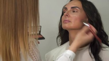 Makyaj sanatçısı güzel bir kız için profesyonel makyaj yapar..