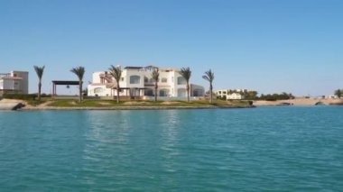 Mısır 'ın El Gouna şehrindeki kanalların kıyısındaki binalar. Yüzen bir tekneden görüntü