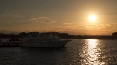 Mısır. Gün batımında güneşin arka planına karşı rıhtımdaki turist tekneleri.