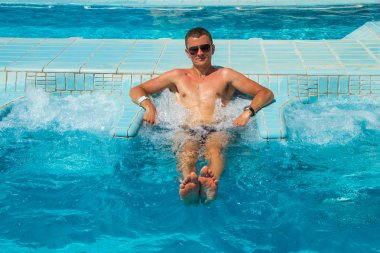 Atletik kendine güvenen adam havuzunda rahatlatıcı spa açık Jakuzi tesisi lüks hayatın tadını. Başarı, sağlıklı yaşam, vücut bakım kavramı.