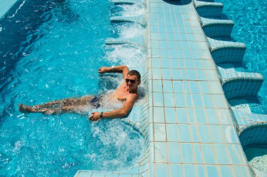 Mutlu tabaklanmış gülümseyen adam havuzunda rahatlatıcı spa açık Jakuzi zevk lüks yaşam tesisi. Başarı, sağlıklı yaşam, vücut bakım kavramı.