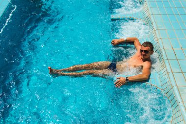 Mutlu atletik gülümseyen adam havuzunda rahatlatıcı spa açık Jakuzi zevk lüks yaşam tesisi. Başarı, sağlıklı yaşam, vücut bakım kavramı.