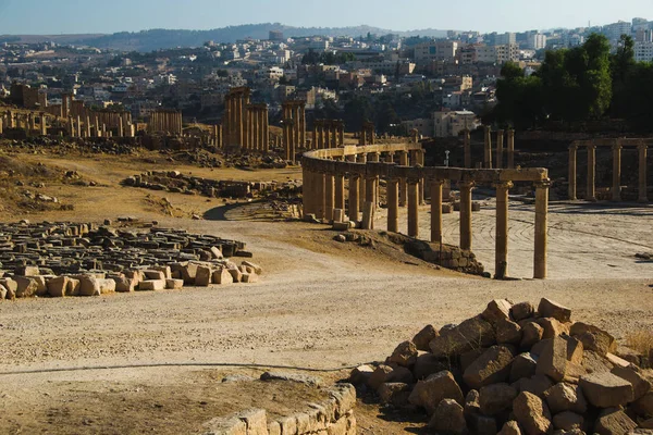 Görünüm Oval Forum ve uzun Sütunlu Cadde veya Decumanus antik Greko-Romen şehir Gerasa kalıntıları. Modern Jerash arka plan üzerinde. Turizm endüstrisi, turistik, seyahat kavramı.