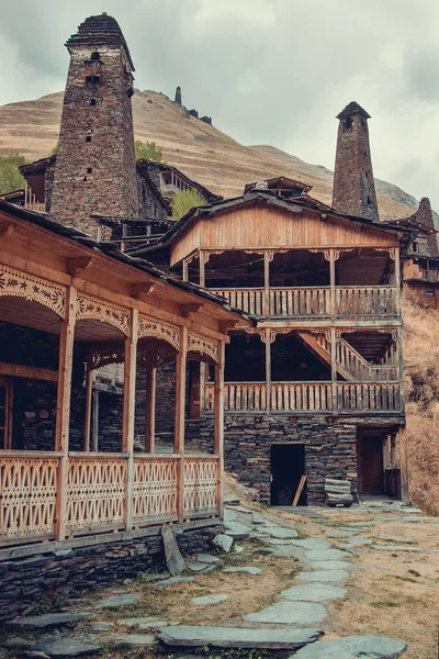 Village Dartlo with traditional stone buildings and defensive towers in Tusheti. Adventure holiday. Travel to Georgia. Ecology tourism. Eco trekking tour. Balcony decorated with fretwork. Vertical — Stock Photo, Image