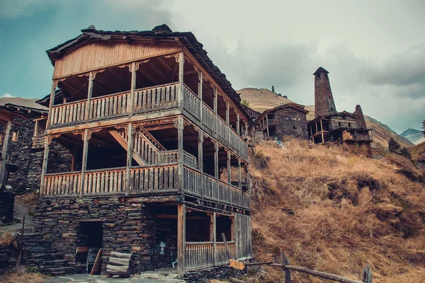 Casa tradicional na aldeia Dartlo com torres de pedra defensiva em Tusheti. Férias de aventura. Viaje para a Geórgia. Turismo ecológico verde. Eco excursão de trekking. Varanda decorada com fretwork — Fotografia de Stock