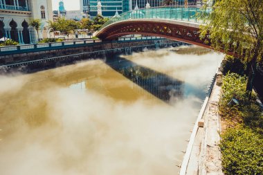 Köprüyü geçince Gombak Nehri. Puslu su. Kuala Lumpur cityscape. Bağlantı kavramı. Malezya için seyahat. Nehir setin. Şehir turu. Turizm endüstrisi. Kentsel arka plan. Şehir Merkezi Parkı.