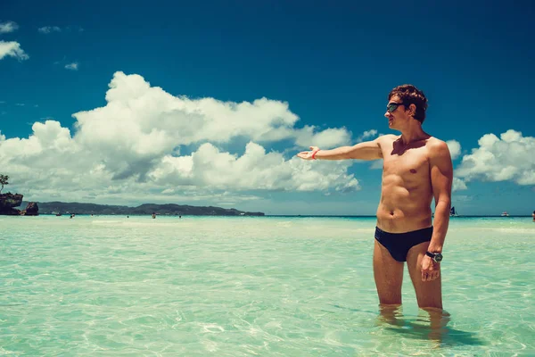 Caucasian man welcoming to paradise enjoying summer beach vacation. Time to travel. Stress free. Shirtless fit athletic male body. Exotic luxury holiday. Tourism concept. Copy space. Wear swimsuit — Stock Photo, Image