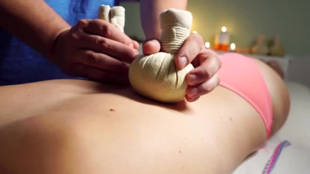 Il massaggio con le buste alle erbe è una procedura rilassante. Primo piano — Video Stock