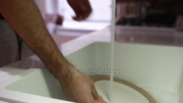 Человек моет посуду в раковине — стоковое видео