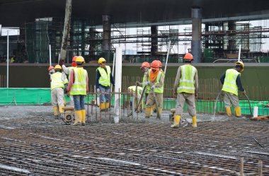 Bir grup inşaat işçileri beton zemin döşeme formu çalışma içine dökme