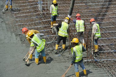 Bir grup inşaat işçileri beton zemin döşeme formu çalışma içine dökme