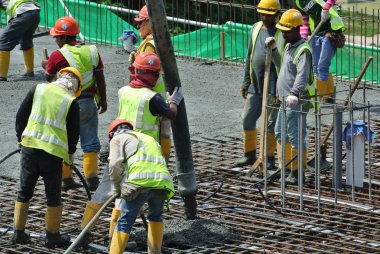 Bir grup inşaat işçileri beton zemin döşeme formu çalışma içine dökme