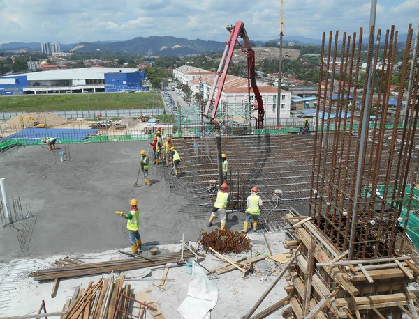 Um grupo de trabalhadores da construção que despeja concreto no trabalho forma laje piso — Fotografia de Stock