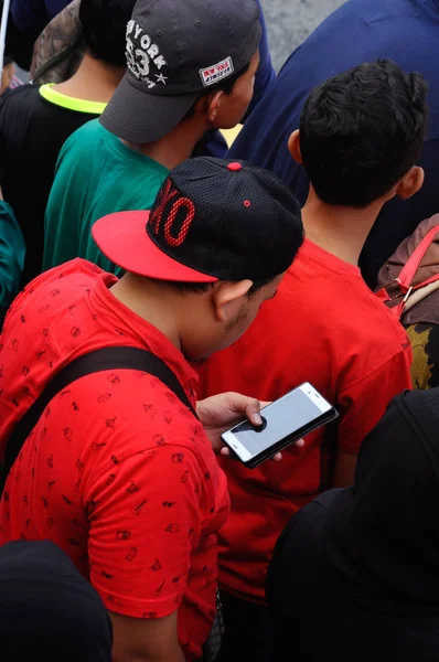 Un hombre usando su teléfono móvil en público . — Foto de Stock