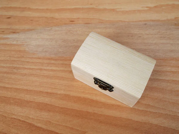 Kleine houten doos op houtnerf achtergrond. — Stockfoto