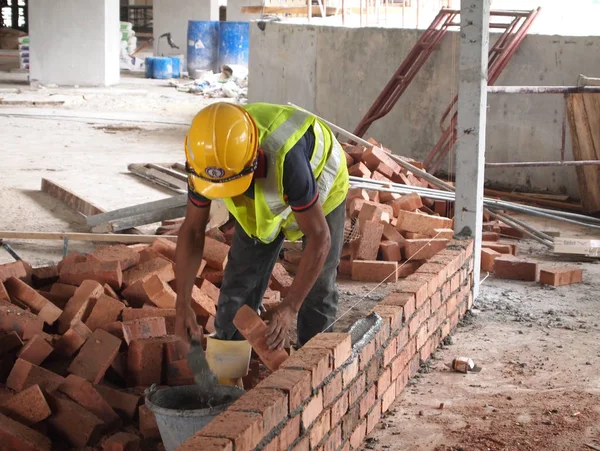 Trabalhadores da construção civil que colocam tijolo de argila — Fotografia de Stock