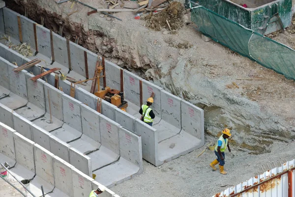 Строители устанавливают водоотвод из сборного бетона на строительной площадке . — стоковое фото