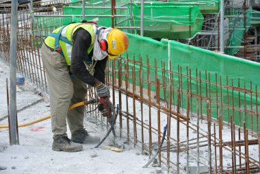 Ağır hareket eden hacker makine inşaat işçileri beton elektrik kullanarak kesmek yeti 