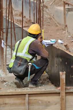  İnşaat işçileri inşaat alanında çelik takviye çubuğu üretiyorlar.