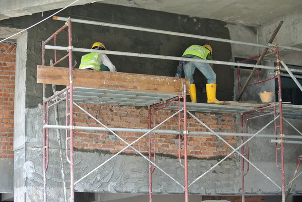 Duvar ve ışın kullanarak çimento alçı sıvama inşaat işçileri — Stok fotoğraf