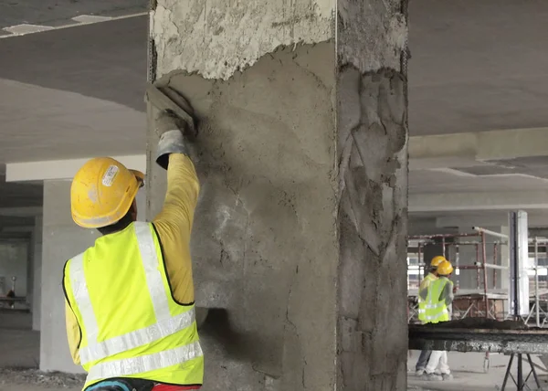 Trabajadores de la construcción que enyesan pared y viga usando yeso de cemento — Foto de Stock