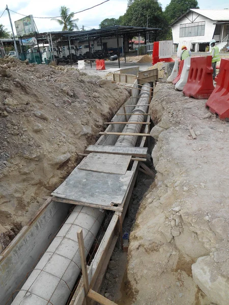 Trabalhadores da construção instalam bueiro de concreto pré-moldado subterrâneo — Fotografia de Stock