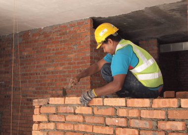 ricklayer işçi kırmızı kil tuğla duvarlar inşa forma yatıyordu