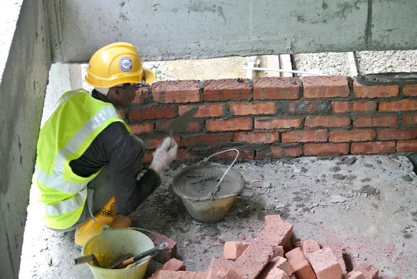 Ricklayer trabajador poner ladrillos de arcilla roja para formar paredes de construcción —  Fotos de Stock