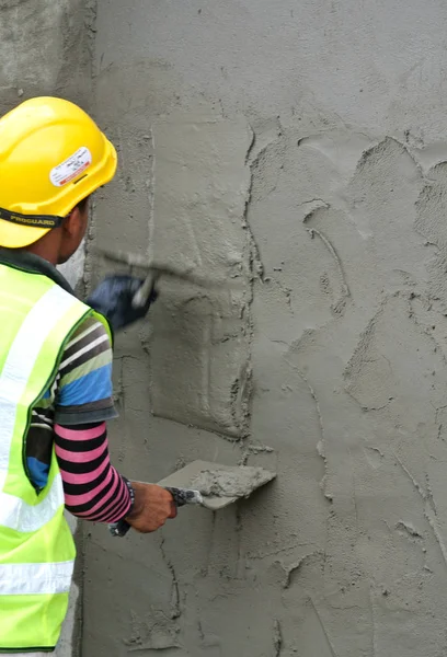 Stavební dělník omítky zdi pomocí cementové omítky — Stock fotografie