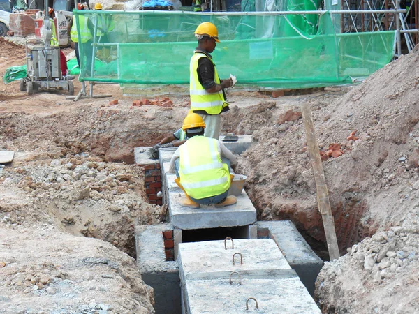 Építőipari munkavállalók telepíteni, földalatti előregyártott beton doboz culvert csatorna — Stock Fotó