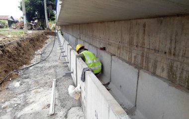 İnşaat İşçileri prekast u şeklinde beton drenaj inşaat sahasında yükleme.