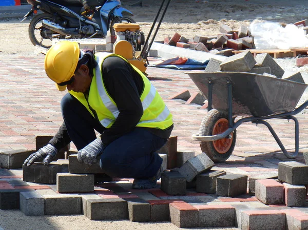 Pekerja konstruksi memasang dan mengatur pasangan batu beton precast — Stok Foto