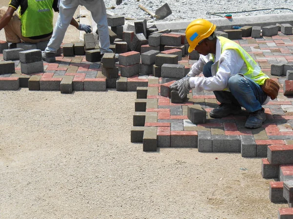 Строители устанавливают и устанавливают сборные бетонные тротуары — стоковое фото