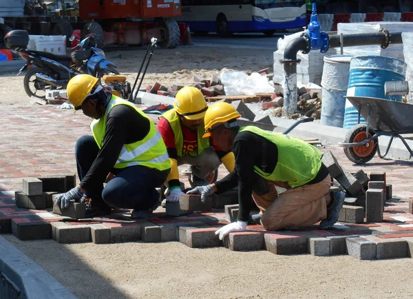 Pekerja konstruksi memasang dan mengatur pasangan batu beton precast — Stok Foto