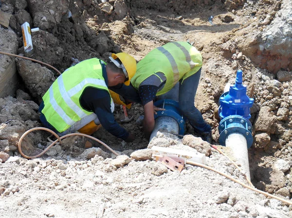 Építőipari munkavállalók telepíteni, föld alatti segédprogram és a cső szolgáltatások. — Stock Fotó