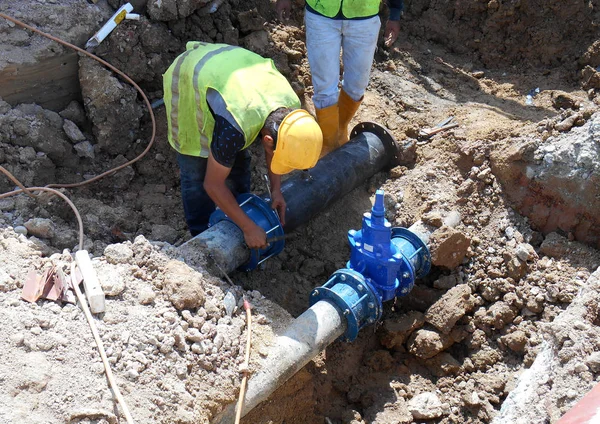 Construction workers install underground utility and services pipe. — Stock Photo, Image