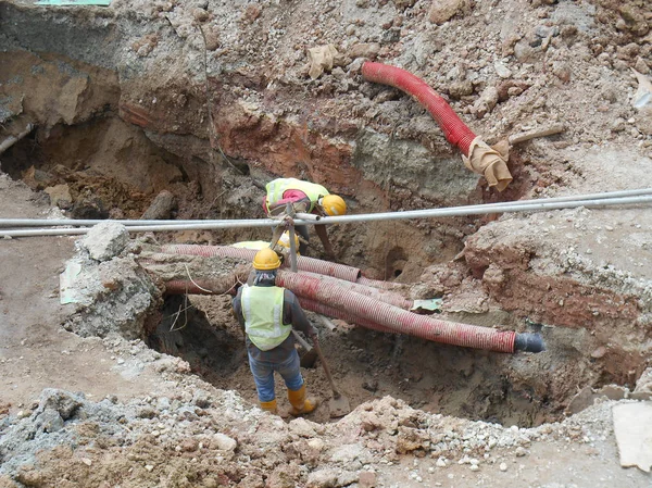 Építőipari munkavállalók telepíteni, föld alatti segédprogram és a cső szolgáltatások. — Stock Fotó