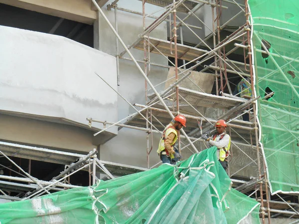 Werknemers in de bouw werken op hoogte op de bouwplaats. — Stockfoto