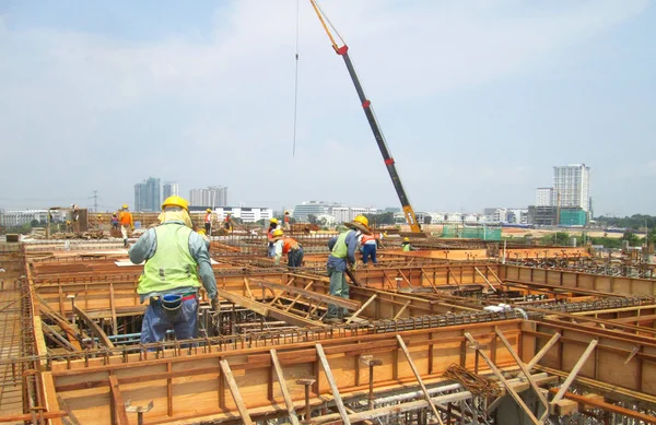 Trabajadores de la construcción que fabrican madera forman trabajo en el sitio de construcción —  Fotos de Stock