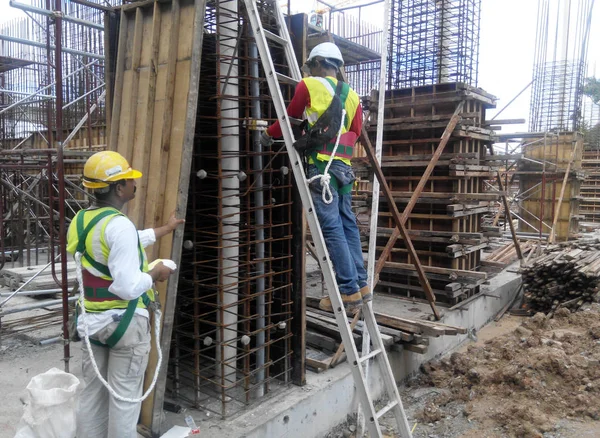 Trabajadores de la construcción que fabrican madera forman trabajo en el sitio de construcción — Foto de Stock