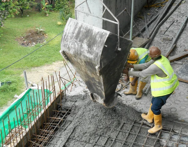 Bouwvakkers gieten natte beton met behulp van concrete emmer — Stockfoto