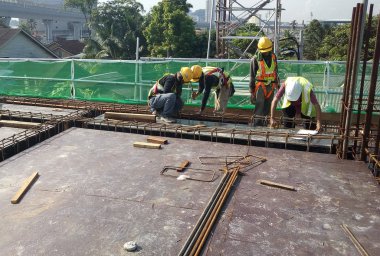 Kuala Lumpur, Malezya-14 Ocak 2017: çelik takviye bar inşaat sahasında imalatı inşaat işçileri. Takviye çubuğu birlikte küçük tel kullanarak bağlıydı.  