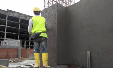 Kuala Lumpur, Malezya-14 Ocak 2017: inşaat işçileri bina duvar ve çimento kullanarak ışın sıvama alçı çimento ve kum inşaat sahasında karışımı. 