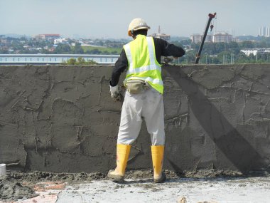 Kuala Lumpur, Malezya-14 Ocak 2017: inşaat işçileri bina duvar ve çimento kullanarak ışın sıvama alçı çimento ve kum inşaat sahasında karışımı. 