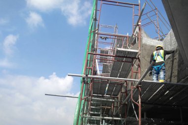 Kuala Lumpur, Malezya-14 Ocak 2017: inşaat işçileri bina duvar ve çimento kullanarak ışın sıvama alçı çimento ve kum inşaat sahasında karışımı. 