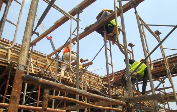 Trabajadores de la construcción que fabrican madera forman trabajo en el sitio de construcción — Foto de Stock