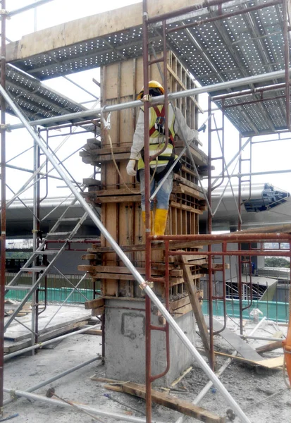 Construction workers fabricating column timber form work and reinforcement bar — Stock Photo, Image