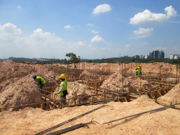 Construção de barra de reforço de viga de terra e trabalho de forma fabricado no local por trabalhadores da construção . — Fotografia de Stock