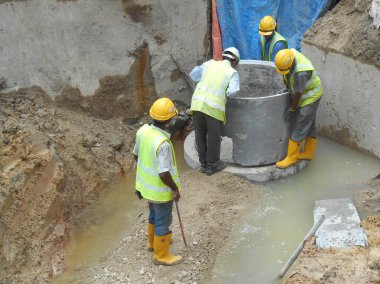 İnşaat İşçileri prekast yeraltı drenaj yüklemek